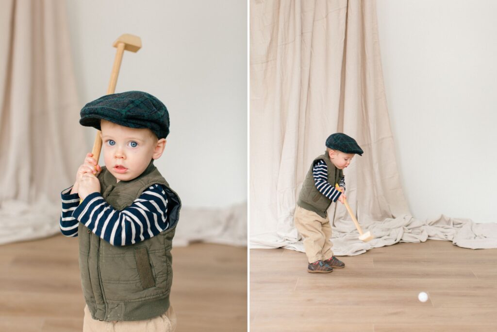 toddler wearing a cap playing golf in a bright neutral studio