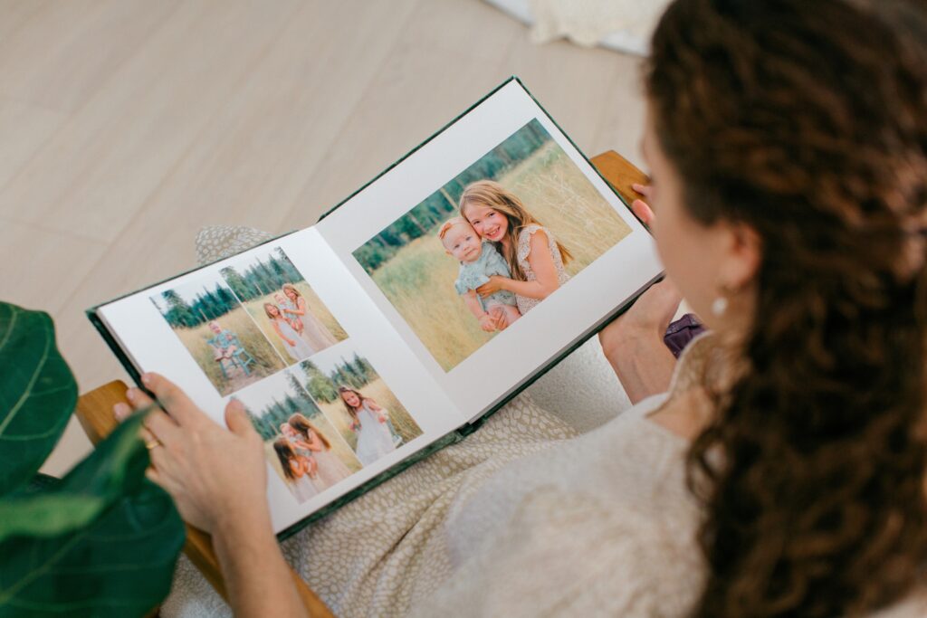 mom looking at heirloom photo album of her family portraits taken in Coeur d'Alene