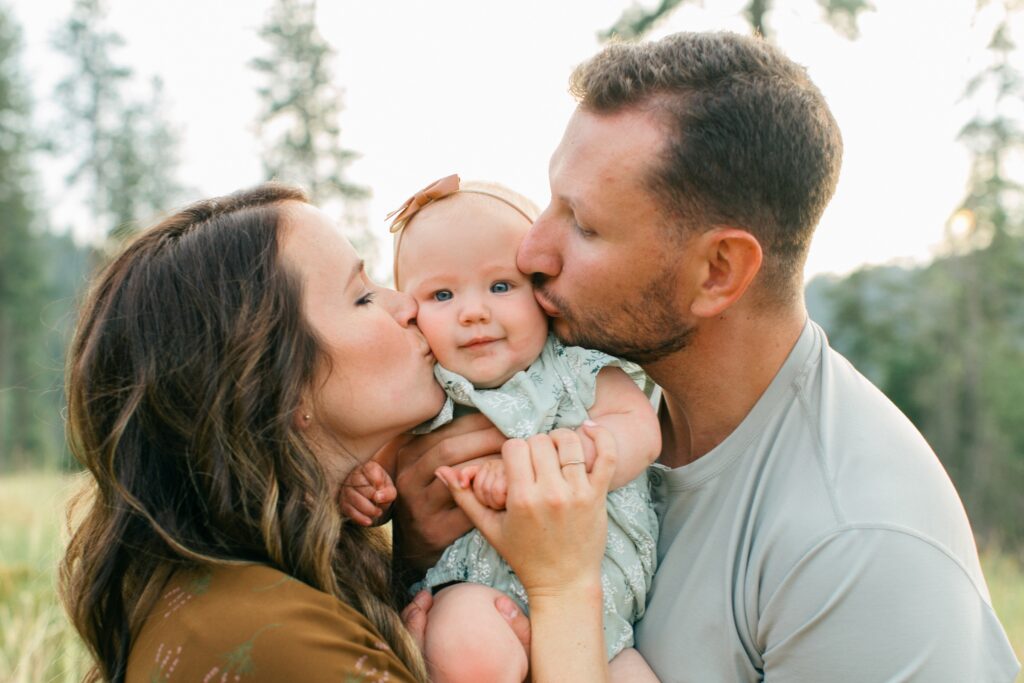 mom and dad kissing baby girl's cheeks during a photo session in Coeur d'Alene Idaho