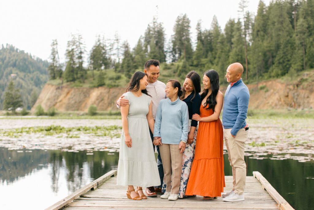 adult children smiling at mother during candid moment of an extended family session