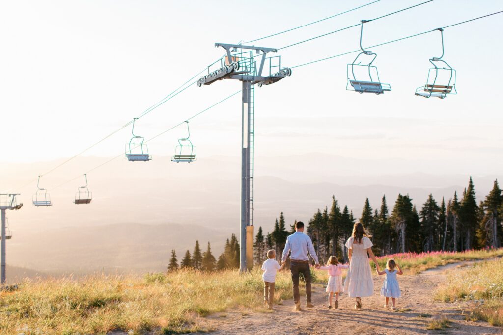 Family standing on Mt Spokane summit during golden hour photography session